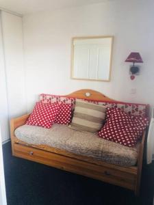 a bed with red and white pillows on it at Appartement risoul 1850 residence pegase in Risoul