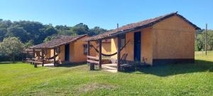 a row of cottages in a field of grass at Fazendinha da Canastra in Vargem Bonita