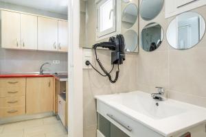 ein Badezimmer mit Waschbecken und Telefon an der Wand in der Unterkunft Agua Mundo 7-2 Apartment Levante Beach in Benidorm + 19 Fotos