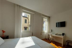 a bedroom with a bed and a desk and a television at Casa del Corso in Pordenone