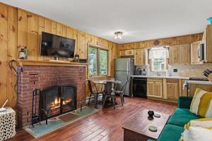 a living room with a brick fireplace and a kitchen at Takundewide Retreat in Lake George