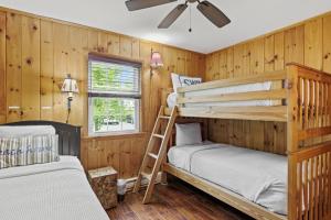 two bunk beds in a room with wooden walls at Takundewide Retreat in Lake George