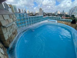a large blue swimming pool on top of a building at Apto estilo chalé em Ponta Negra in Natal