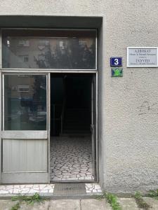 an open door of a building with a sign in it at Apartman Central A&D in Bečej