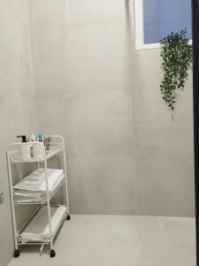 a white tiled bathroom with a towel rack at EVA Apartment in Novi Sad