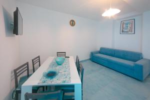 a living room with a table and a blue couch at Scinniamare in Cefalù