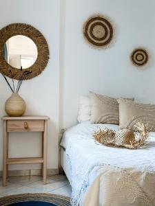 1 dormitorio con cama con espejo y mesa en Blue Seaside House with Garden, en Skala Eresou