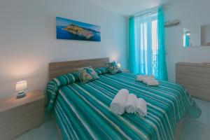 a bedroom with a bed with towels on it at Scinniamare in Cefalù