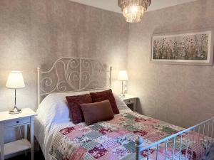 a bedroom with a bed with a quilt on it at Divine, detached countryside cottage near Ludlow. in Ludlow