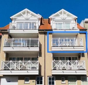 zwei Apartmenthäuser mit weißen Balkonen darauf in der Unterkunft Appartement moderne 2 chambres et grand balcon in Knokke-Heist