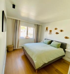 ein Schlafzimmer mit einem großen Bett und einem Fenster in der Unterkunft Appartement moderne 2 chambres et grand balcon in Knokke-Heist