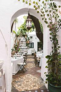 an archway with tables and chairs in a restaurant at Doña Lola Rooms in Conil de la Frontera
