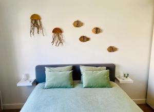 ein Schlafzimmer mit einem Bett mit zwei Kissen und einigen Muscheln an der Wand in der Unterkunft Appartement moderne 2 chambres et grand balcon in Knokke-Heist