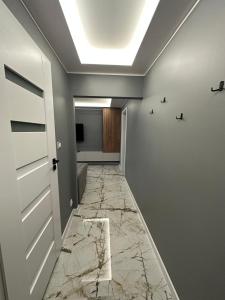 a hallway with marble flooring and a ceiling at Apartament Centrum 2-pokojowy Klimatyzacja nr 6 in Radom