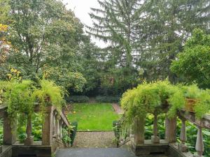 einen Garten mit einer Brücke und einem Garten mit Bäumen in der Unterkunft Quaint Mansion in Stagno Lombardo with Garden in Stagno Lombardo