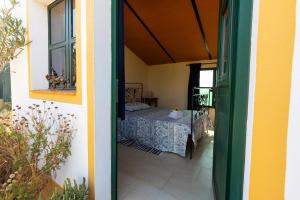 an open door to a room with a bed at Ninho Da Poupa in Serpa