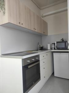 een keuken met witte kasten en een fornuis met oven bij BRIGHT CITY CENTER Apartment - FlexibleCheckins in Zagreb