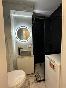 a bathroom with a toilet and a sink and a mirror at Apartament Centrum 2-pokojowy Klimatyzacja nr 6 in Radom