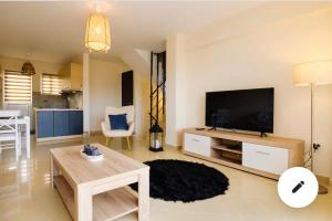 un soggiorno con grande TV e tavolo di Marathon Luxury Suites - 2 bedroom a Schinias