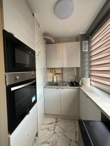 a small kitchen with a microwave and a sink at Apartament Centrum 2-pokojowy Klimatyzacja nr 6 in Radom