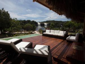 eine Terrasse mit Sofas und Blick auf einen Wasserfall in der Unterkunft Waka Wená in Santa Elena de Uairén
