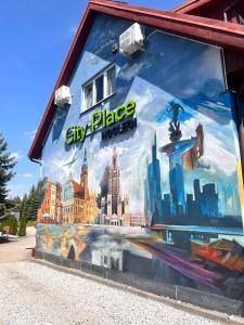 un mural en el lateral de un edificio de la ciudad en City Place Noclegi, en Wroclaw