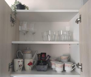 a cupboard filled with lots of cups and dishes at BRIGHT CITY CENTER Apartment - FlexibleCheckins in Zagreb