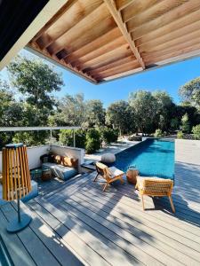 une terrasse avec une piscine et une pergola en bois dans l'établissement Aria Cigala, à Bonifacio