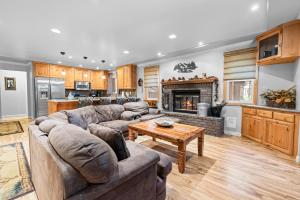 a living room with a couch and a table and a kitchen at Summit Condo - Luxury condo, walk to the slopes! in Big Bear Lake