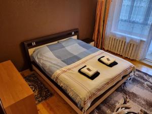 a bedroom with a bed with two pillows on it at Eva's apartments in Kaunas