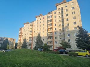 a large building with cars parked in a parking lot at Eva's apartments in Kaunas