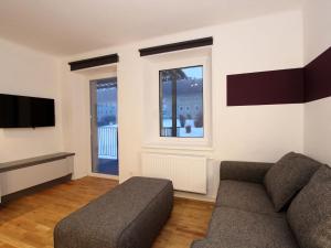 ein Wohnzimmer mit einem Sofa und einem TV in der Unterkunft Hilltop Apartment in Eisenerz with Garden in Eisenerz