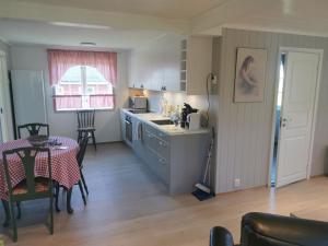 a kitchen and dining room with a table and a table and chairs at Feriebolig på bygda in Straumsjøen