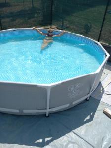 a person swimming in a large swimming pool at Guest House Jevtović in Sremski Karlovci