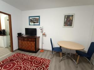 a room with a table and chairs and a table and a tv at Sonnenkalb in Todtmoos