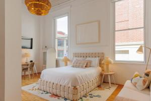 a white bedroom with a large bed and a table at Fire Station One Boutique Hotel in Roanoke