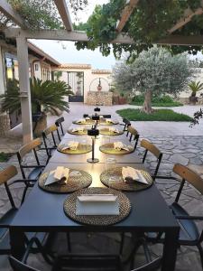 - une longue table noire avec des chaises et des serviettes dans l'établissement Terra Dei Limoni, à Noto Marina