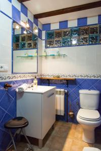 a blue and white bathroom with a toilet and a sink at Casa El Campano in Ontaneda