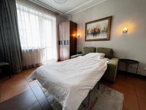 una camera con un letto e una sedia e una finestra di Kyiv Romantic Studio a Kiev