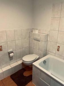 a bathroom with a toilet and a bath tub at BySeyn - 60qm mitten in der Erfurter Altstadt in Erfurt