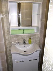 a bathroom sink with a mirror and a green towel at Apartment Vrančić in Šibenik