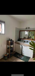 a bathroom with a sink and a desk with a mirror at La Villa Manee in La Saline les Bains