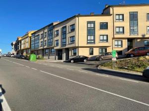 een lege straat met auto's voor gebouwen bij Apartamento Antia in Fisterra