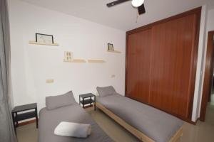 een kamer met 2 bedden en een houten deur bij Apartamento Antia in Fisterra