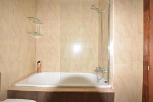 een badkamer met een bad en een douche bij Apartamento Antia in Fisterra +16 foto's