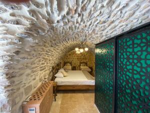 a bedroom with a bed in a brick wall at Hanedan Konağı Butik Otel in Yaylacık