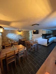 a restaurant with wooden tables and chairs and a stone wall at Penzion Loket in Loket