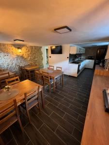 um restaurante com mesas e cadeiras de madeira e uma cozinha em Penzion Loket em Loket
