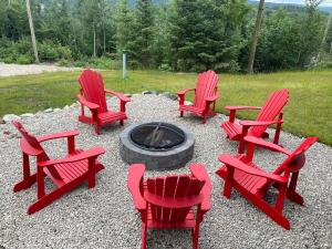 a group of red chairs around a fire pit at Au Coin Du Belvédère in Saint Come