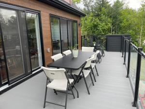 a patio with a black table and chairs at Au Coin Du Belvédère in Saint Come